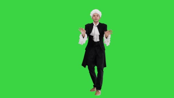 Mand klædt som Mozart udtryksfuldt efterbehandling ledende mens man ser på kameraet på en grøn skærm, Chroma Key. – Stock-video