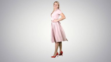 Pembe elbiseli kadın arkasını dönüyor ve aynadaki gibi kendine bakıyor..