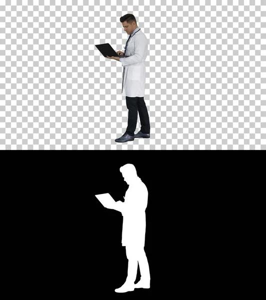 Man wearing white medical coat and stethoscope walking with laptop, Alpha Channel — Stock Photo, Image