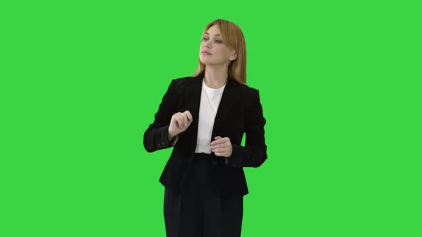 緑の画面上の彼女の側に仮想オブジェクトを指して何かを提示若いビジネス女性,クロマキー. — ストック動画