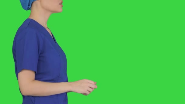 Kvinnlig läkare i blå uniform talar om sjukvård på en grön skärm, Chroma Key. — Stockvideo