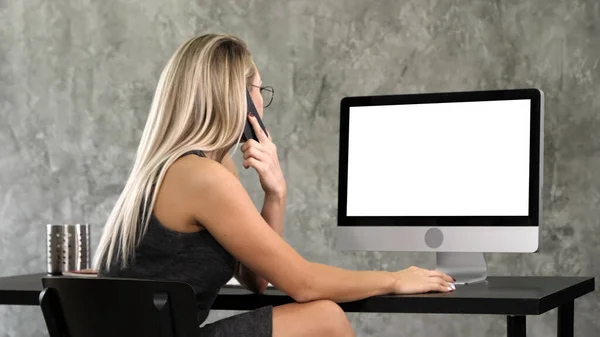 Hermosa joven empresaria trabajando en la computadora y haciendo una llamada. Pantalla blanca. — Foto de Stock