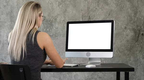 Joven mujer de negocios que trabaja en el interior de la oficina en la PC en el escritorio, escribiendo, mirando a la pantalla. Pantalla blanca. — Foto de Stock