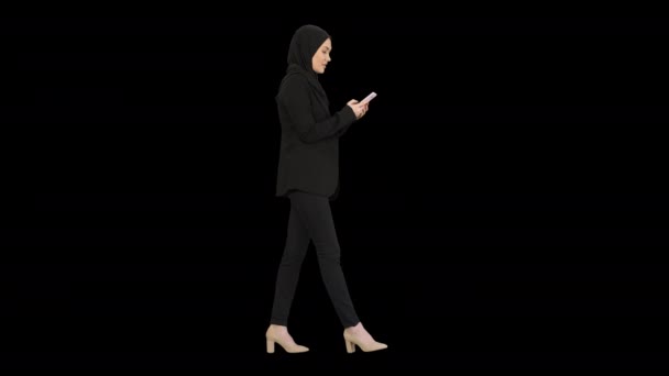 Kvinna i hijab med hjälp av mobiltelefon promenader, Alpha Channel — Stockvideo