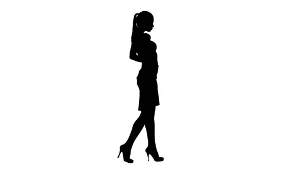 Silhouette Bella giovane donna in abito elegante camminare, tenendosi per mano sui fianchi. — Foto Stock