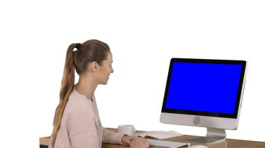Girl sitting in front of the computer monitor and watching something smiling Blue Screen Mock-up Display on white background. clipart