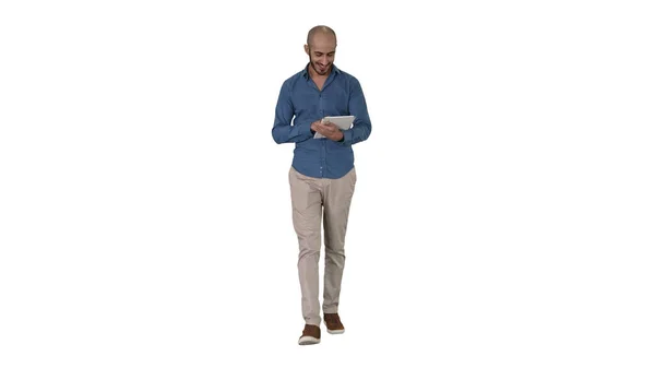 Homem árabe andando e usando internet tablet surf no fundo branco. — Fotografia de Stock