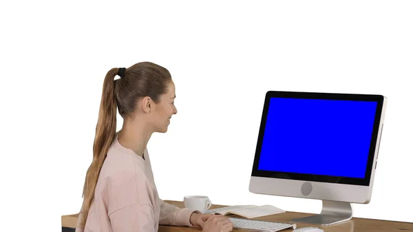 Flicka sitter framför datorskärmen och titta på något leende blå skärm Mock-up Visa på vit bakgrund. — Stockfoto