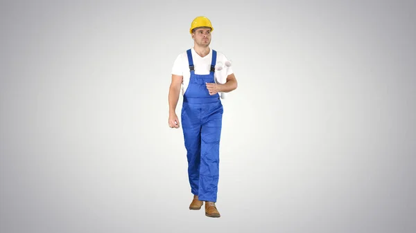 Inspector ingeniero hombre mirando a su alrededor mientras camina sobre fondo gradiente. — Foto de Stock