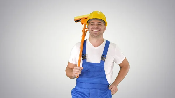 Housecleaner en casco caminando con una fregona sobre fondo degradado. — Foto de Stock