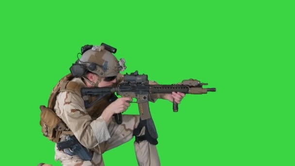 Парашутист у формі стріляє з позиції сидячого на зеленому екрані, Chroma Key. — стокове відео