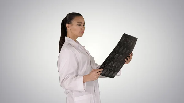 지능적 인 여성 의료 인력흰 래 브 코트를 입고 x-ray 라디오그래피 이미지를 보고 , ct 스캔을 보고, 경사 배경에 mri. — 스톡 사진