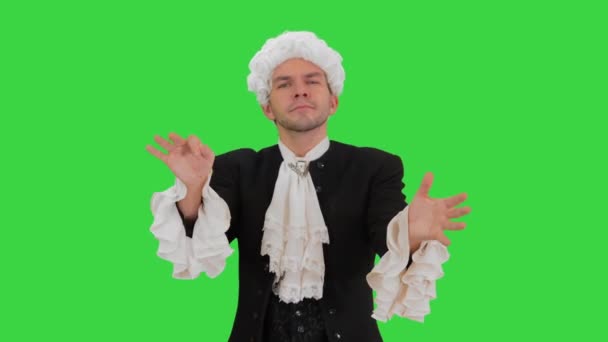 Mężczyzna ubrany jak Mozart dyrygujący ekspresyjnie patrząc w kamerę na zielonym ekranie, Chroma Key. — Wideo stockowe