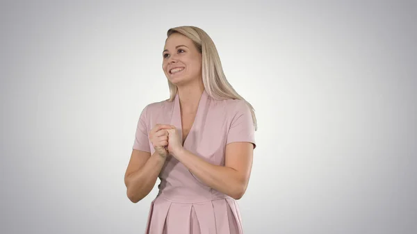 Mulher de rosa falando com a câmera no fundo gradiente. — Fotografia de Stock