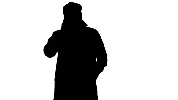 Silhouette Mann im Trenchcoat telefoniert beim Gehen. — Stockfoto