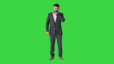 Konuşma kullanan işadamı, yeşil ekran, Chroma Key 'de akıllı telefondan sanal dijital ses asistanını etkinleştir.