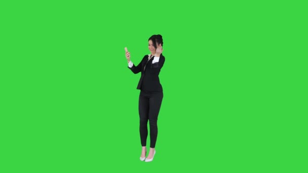 Donna d'affari guardare in smart phone preening e ballare su uno schermo verde, Chroma Key. — Video Stock