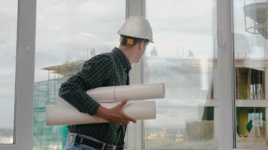 Mühendis pencereden inşaatı kontrol ediyor..