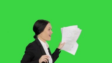 Heyecanlı iş kadını elinde bir sürü kağıtla yeşil ekranda dans ediyor, Chroma Key..
