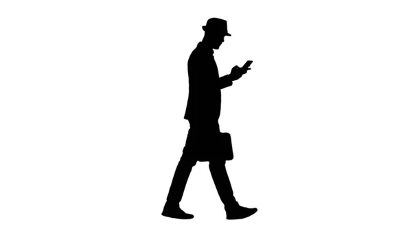 Силуэт человека, который разговаривает по телефону и ходит пешком. — стоковое фото