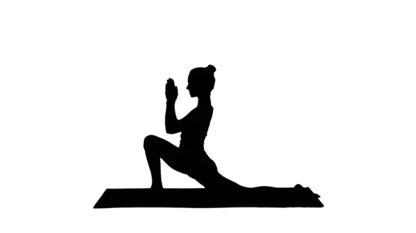 Silhouette Sportliches attraktives Mädchen, das Yoga praktiziert, in Reiterübungen steht, in anjaneyasana-Pose. — Stockfoto