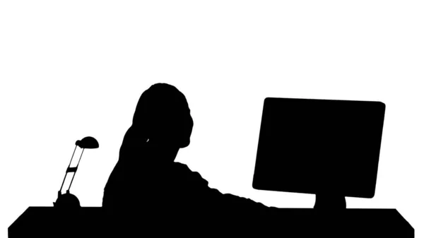 轮廓快乐的女人坐在桌旁，办公室里拿着一台电脑，微笑着看着摄像机. — 图库照片