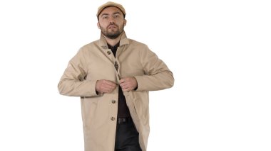 Soğuk hava Sonbahar ya da Kış Günü Çukurdaki Adam beyaz arka planda düğmelerini ilikliyor.