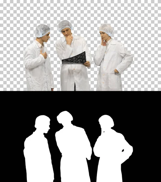 Três médicos ritmicamente olhar para uma foto de raio-x de um paciente t — Fotografia de Stock