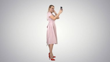 Güzel bir kadın arka planda telefonuna bakıyor..