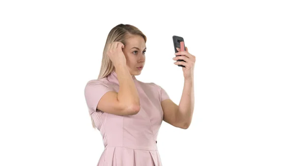 Mujer rubia acariciándose delante del teléfono inteligente sobre fondo blanco. —  Fotos de Stock