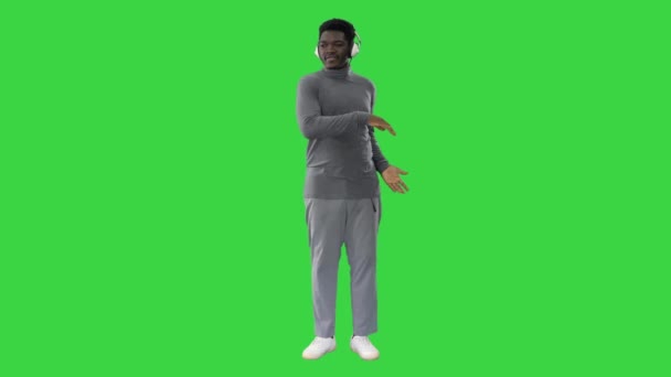 Appassionato afroamericano che ascolta la musica in cuffia e balla su uno schermo verde, Chroma Key. — Video Stock