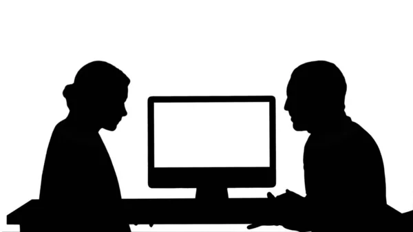 Pessoas de negócios de silhueta que têm reunião em volta do monitor do computador que fala sobre o que está na tela. — Fotografia de Stock