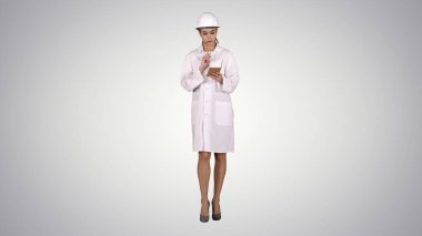 Kadın mühendis, gradyan arka planda yürüyen kontrol listesi yazıyor.