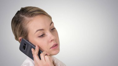 Sarı saçlı bir kadın cep telefonuyla konuşuyor..