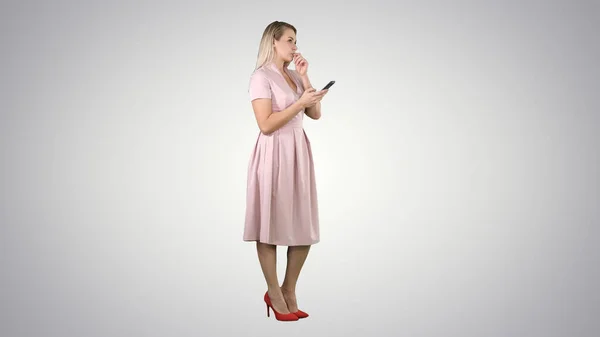 金发少女，带着粉色短信，带着梯度背景的智能手机. — 图库照片