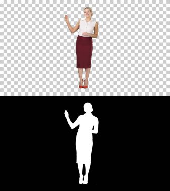 Çekici gülümseyen enerjik kadın resmi kıyafetler içinde kamerayla konuşuyor ve yanlarını işaret ediyor, Alpha Channel.