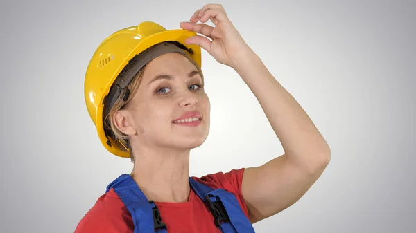 Female construction worker greeting on gradient background. — Stock Photo, Image