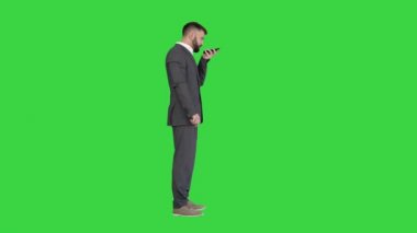 Ciddi bir Türk işadamı telefonda konuşuyor. Sanal dijital ses asistanını yeşil ekranda, Chroma Key 'de aktifleştir..