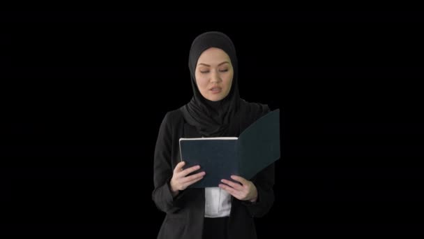Empresaria musulmana leyendo a su planificador de negocios mientras camina a la reunión, Alpha Channel — Vídeos de Stock