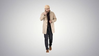 Hafif trençkotlu yakışıklı adam kamerayla konuşuyor. Odaklan ve bunu düşün. Eğilim arka planına işaret ediyor..