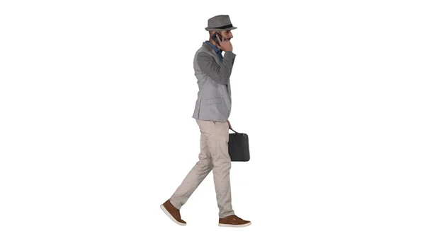 Hombre árabe en casual caminando y haciendo una llamada telefónica sobre fondo blanco. —  Fotos de Stock