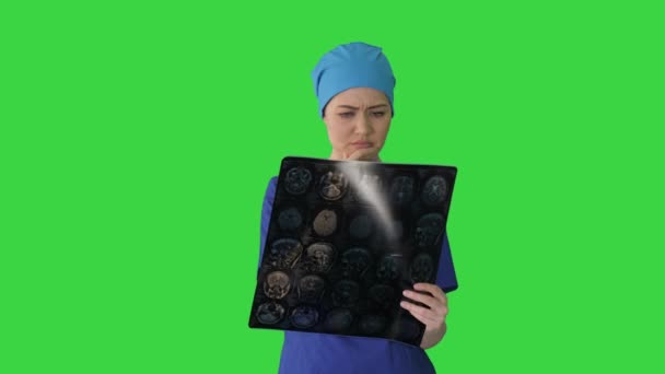 Vrouwelijke arts op zoek naar hersentomografie op een groen scherm, Chroma Key. — Stockvideo