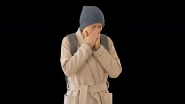 Paltolu bir kadın yürüyor ve öksürüyor, Alpha Channel.