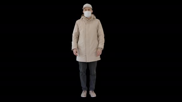 Hombre joven con máscara de gripe de pie sin hacer nada, canal alfa — Vídeos de Stock
