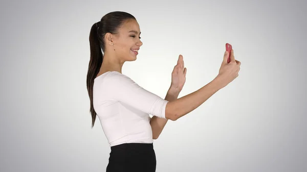 Junge lateinisch-formale Frau, die einen Videoanruf macht oder einen Videoblog über den Hintergrund des Gefälles aufzeichnet. — Stockfoto