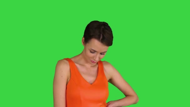 Uma mulher bonita e alegre endireita seu vestido em uma tela verde, Chroma Key. — Vídeo de Stock