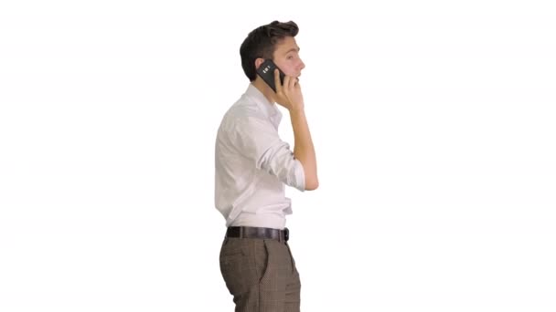 Hombre guapo hablando por teléfono mientras camina sobre fondo blanco. — Vídeos de Stock