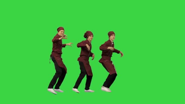 Tres cocineros sonrientes en uniforme rojo se sincronizan bailando sobre fondo verde y apuntando a la cámara al final en una pantalla verde, Chroma Key. — Vídeos de Stock