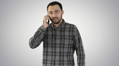 Genç adam telefonda konuşuyor ve arkaplanda yürüyor..