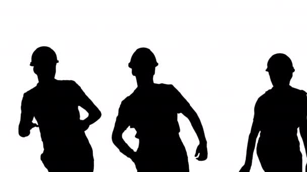 Silueta Tres trabajadores de la construcción masculinos en sombreros duros sincronizan el baile con sus espaldas a la cámara. — Vídeos de Stock